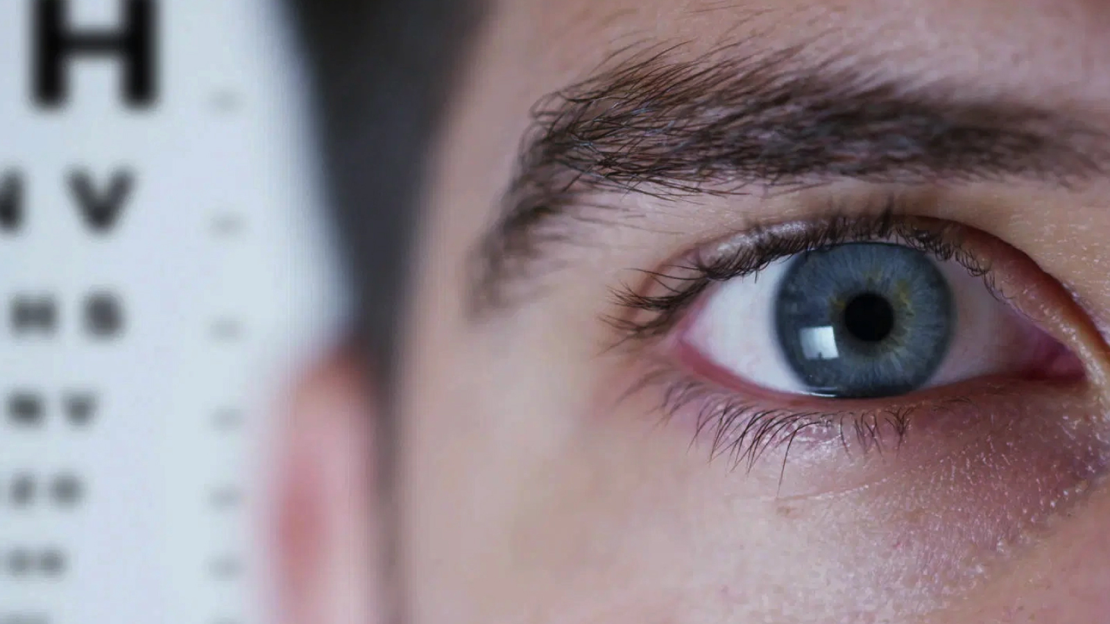 Figure1. Vision screening concept close up of the eye with a Snellen chart in the background